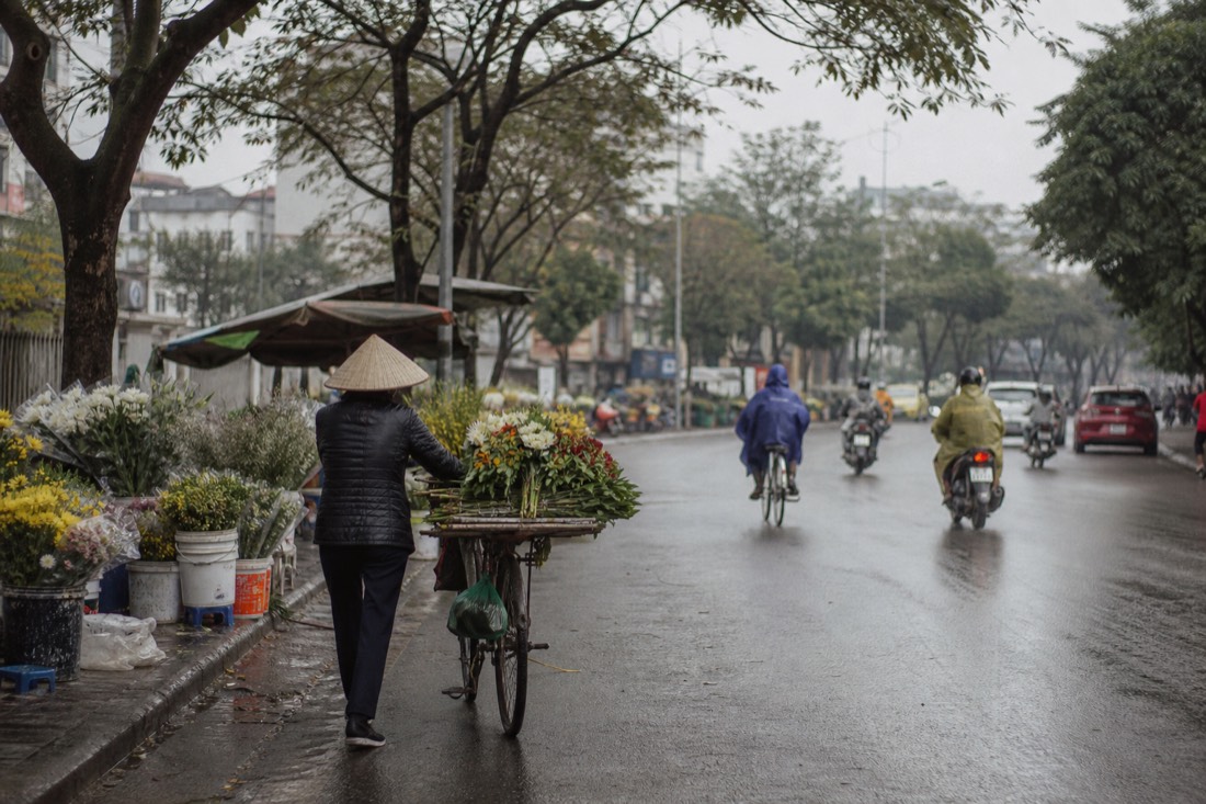 Hazy spring morning light over a Hanoi street with vendors setting up stalls