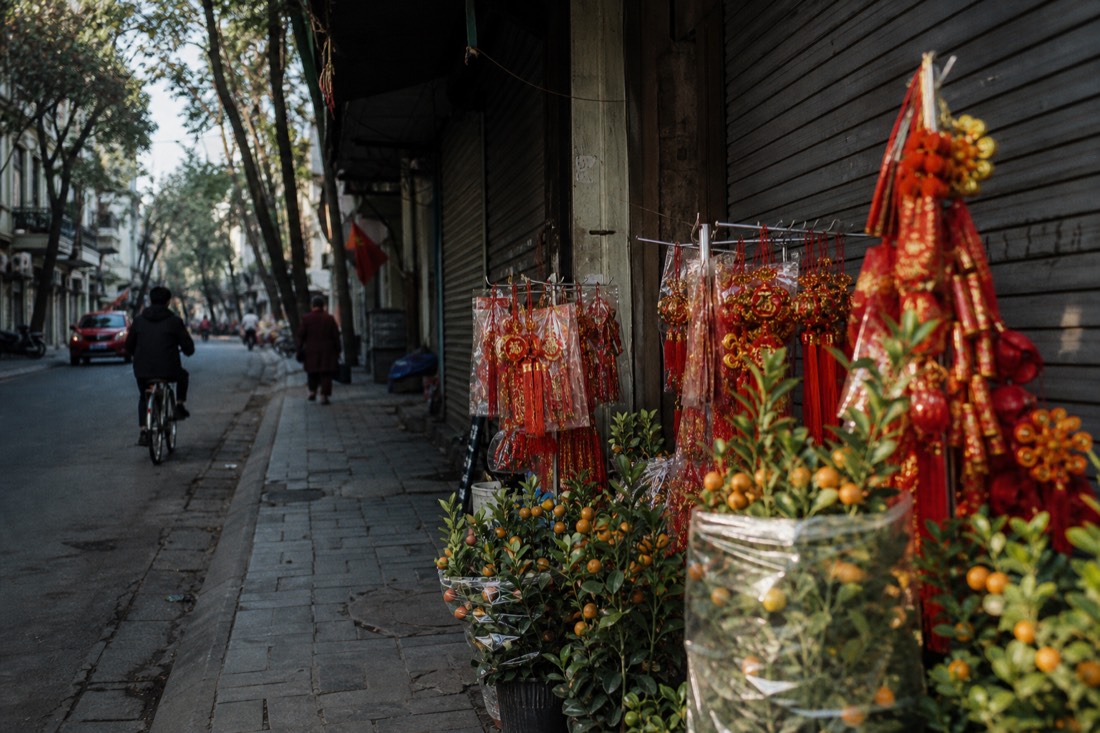 Red and gold Tet decorations outside a closed shopfront on a quiet Hanoi street