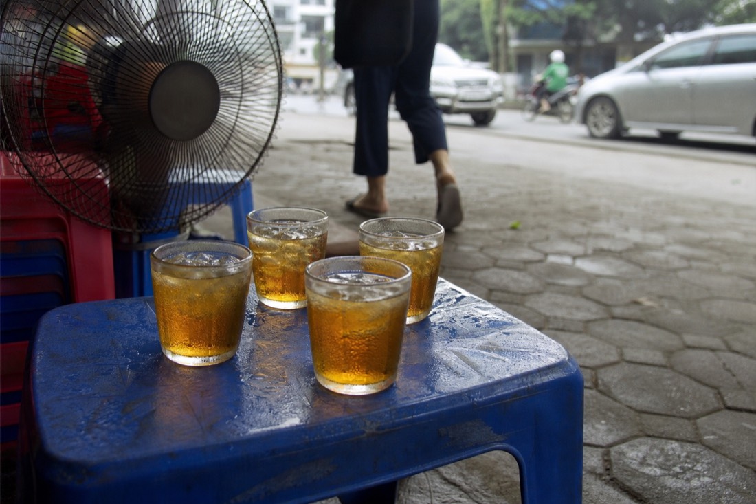 Glasses of iced tea on a low pavement table in Hanoi during hot humid summer weather