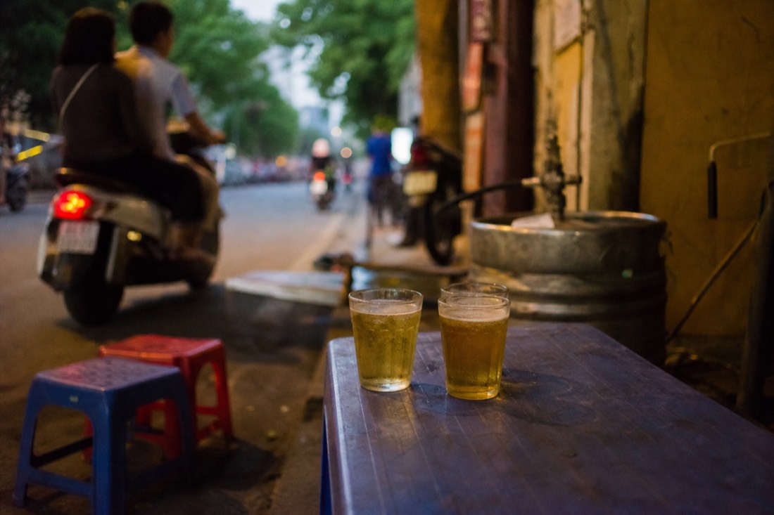 Small glasses of fresh bia hoi on a low table at a corner of Ta Hien street in Hanoi