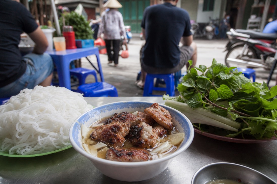 Charcoal-grilled pork patties and noodles served as bun cha at a Hanoi street food stall