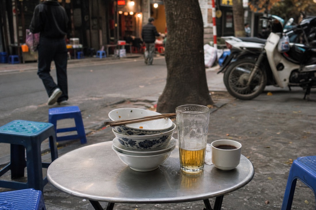 Stack of empty bowls and plates after a round of cheap Hanoi street food dishes