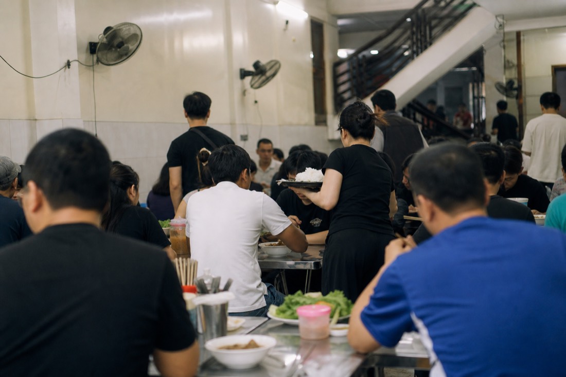 Busy dining floor of a Michelin-listed bun cha restaurant in Hanoi at lunch service