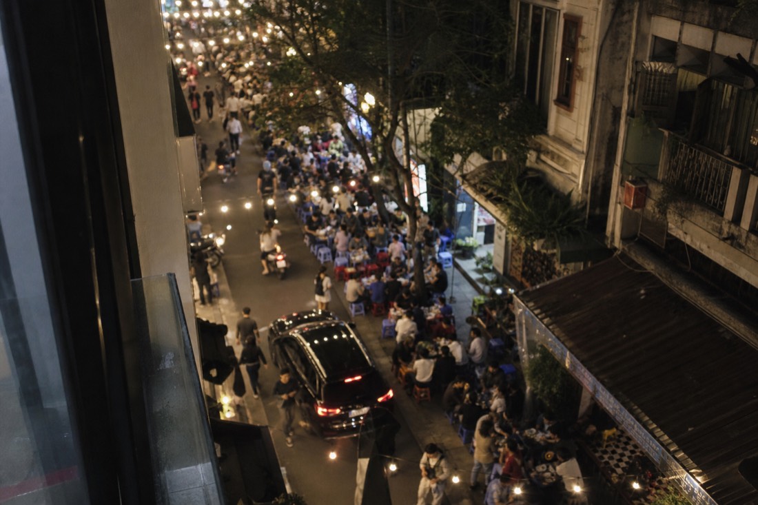 View from a window looking down on a busy bar street below at night